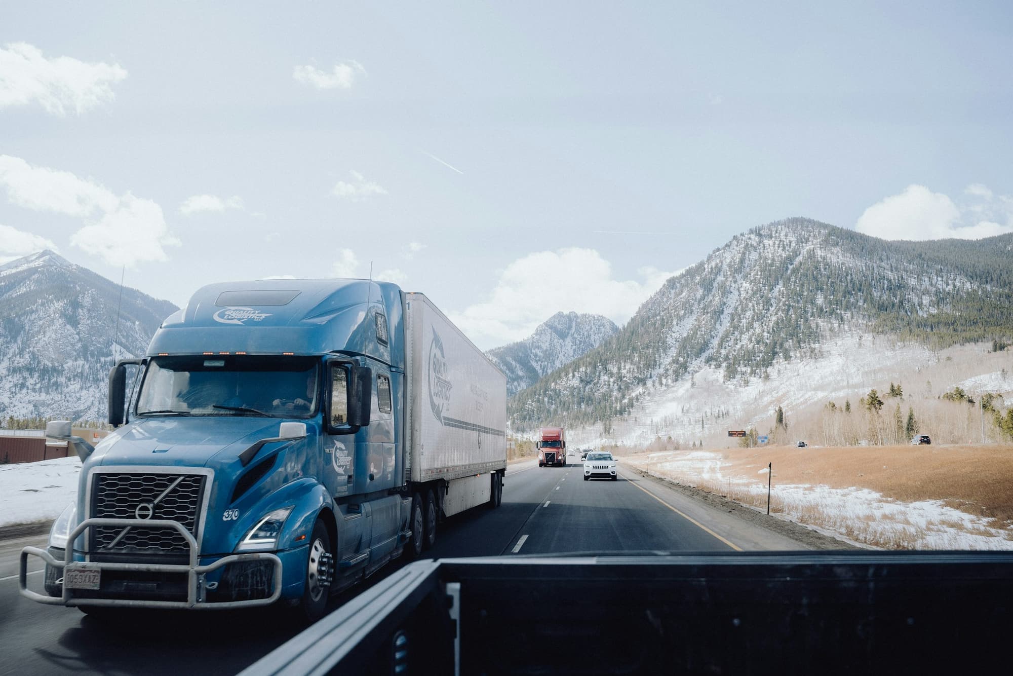 An articulated freight truck on a highway through mountains