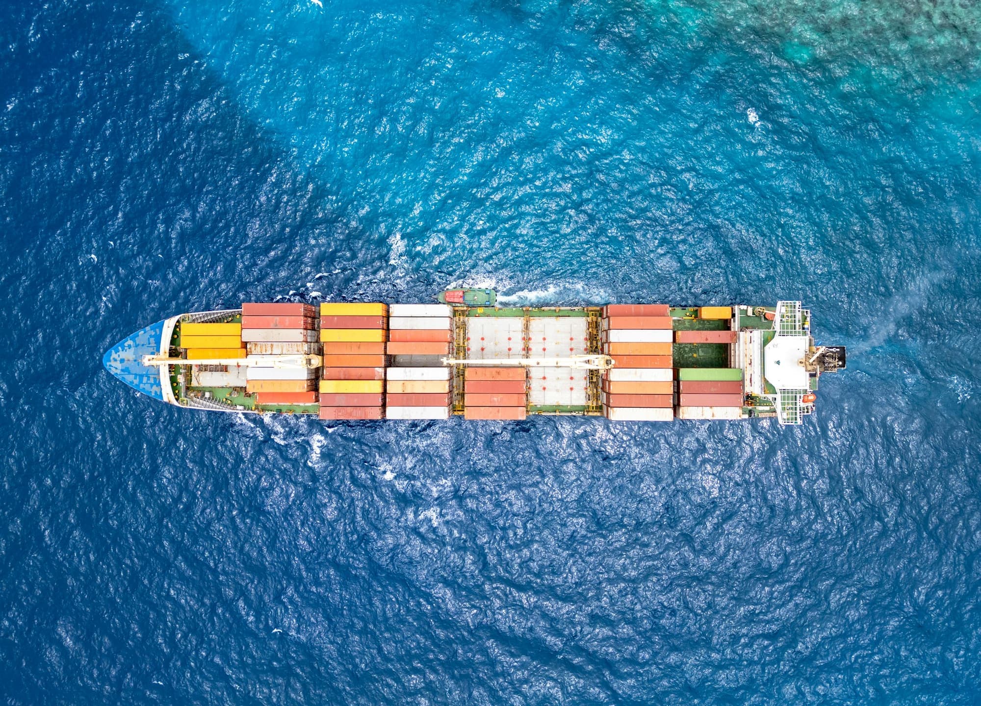 Aerial view of a loaded container ship crossing open ocean