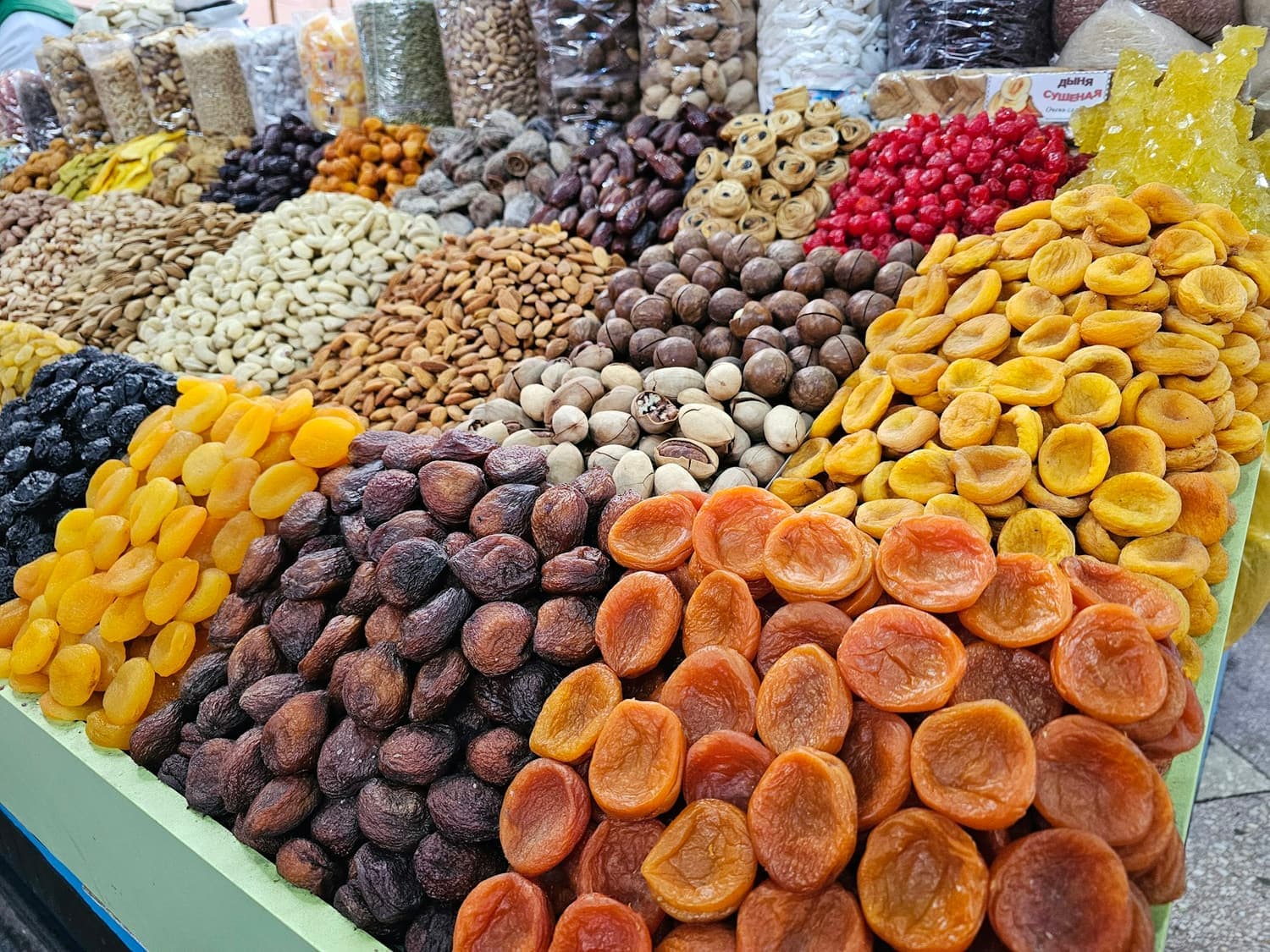Bulk dried apricots, raisins, almonds and pistachios laid out at a wholesale market